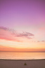 Scenic View Of Purple And Orange Sky Over Sea During Sunrise