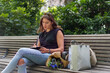© Mattia Pelizzari/Westend61 - Young woman writing in note pad while sitting on bench