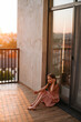 © mihalovna88 - Portrait of a schoolgirl girl in a beautiful pink dress with long hair on a large terrace in the setting sun