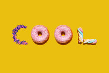 Sugar Sprinkles, Doughnuts And Marshmallows Arranged Into Single Word