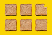Studio Shot Of Six Slices Of Wheat Bread Against Yellow Background