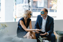 Businessman And Woman Wearing Super Hero Masks, Trying To Find Solutions