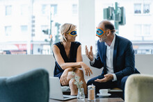 Businessman And Woman Wearing Super Hero Masks, Having A Meeting