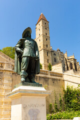 View of medieval fortified tower of Tour d Armagnac and sculptural monument of famous musketeer d Artagnan in French city of Auch..