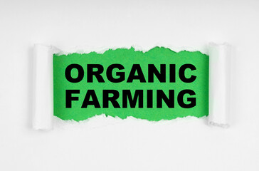 Wall Mural - In the middle of the white sheet, the paper is torn, inside on a green background the inscription - Organic Farming
