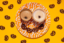 Anthropomorphic Face Made Of Plate, Chocolate Pretzels And Two Glasses Of Coffee