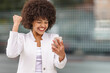 © GER/Westend61 - Cheerful businesswoman showing winning gesture while using mobile phone outdoors