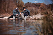 © Derek Henthorn/Westend61 - Fisherman sitting with son at riverbank in forest