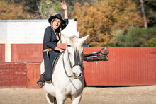 Portrait Of Woman Horseback Riding In Paddock