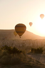 Silhouette Hot Air Balloons Flying Over Landscape Against Clear Sky During Sunset At Goreme National Park, Turkey