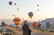 © Konstantin Trubavin/Westend61 - Young woman and hot air ballons, Goreme, Cappadocia, Turkey