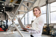© Westend61 - Portrait of smiling young woman using laptop in a factory