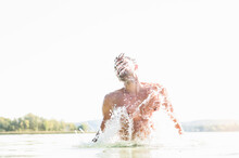 Young Man Splashing In Lake