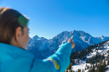 Woman Pointing At Snowcapped Mountain Against Clear Blue Sky
