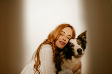Blond Woman At Home In Pijama Hugging Her Border Collie Dog