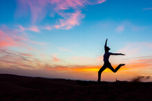 Silhouette Of Woman Jumping At Sunset In The Dunes, Gran Canaria, Spain