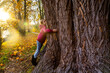 © Sandra Roesch/Westend61 - Girl hugging big tree in autumn