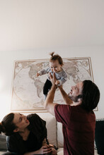 Happy Family Playing With Baby Girl In Living Room At Home