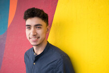 Smiling Young Man Against Multi Colored Wall