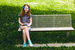 © Irina Hess/Westend61 - Smiling girl listening music through headphones while sitting on bench at park