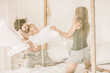 © Derek Henthorn/Westend61 - Carefree young couple having a pillow fight in bed