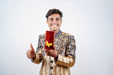 Canvas Print - Indian man holding surprise gift boxes and empty plate on DIWALI or wedding or festivals while wearing traditional cloths standing isolated over white background