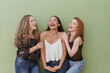 © MORNINGVIEW AGENCY/Westend61 - Multi ethnic female friends laughing against green wall
