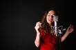 © DREAMSTOCK1982/Westend61 - Portrait of female singer with microphone, wearing red dress
