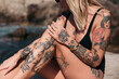© Lucas Ottone/Westend61 - Spain, Mallorca, tattooed woman sunbathing