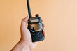 © Ezequiel Gimenez/Westend61 - Hand holding walkie-talkie against wall