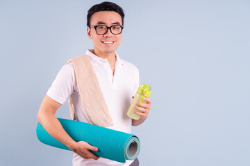 Wall Mural - Asian man wearing sportswear and holding water bottle, gym and yoga concept