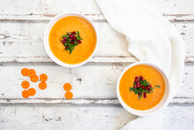 Bowl Of Carrot Ginger Coconut Soup With Topping Of Parsley And Pomegranate Seed