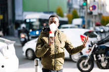Male TV Reporter Wearing Face Mask Talking Over Microphone While Standing On Street