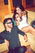 © EDUARDOHUELINPHOTO/Westend61 - Cheerful woman singing karaoke while sitting with male friend in party