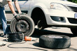 © Roman Maerzinger/Westend61 - Man changing car tires, partial view