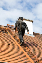 Chimney Sweep Climbing Up House Roof