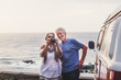 © Simona Pilolla/Westend61 - Senior couple traveling in a vintage van, taking pictures at the sea