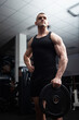 © Valeriia - Portrait of a handsome man in gym. Coach, athlete, bodybuilder, muscular sexy body, darkness. serious