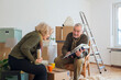 © Maria Maar/Westend61 - Senior couple looking at photo album surrounded by cardboard boxes in an empty room