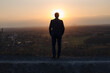 © Westend61 - Mature businessman standing on a disused mine tip at sunset looking at view