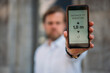 © Westend61 - Close-up of man holding smartphone showing distance on display