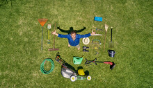 View From Above Of A Gardener In Standing On Meadow With All The Tools He Need For Take Care Of Garden
