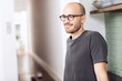 © Maya Claussen/Westend61 - Smiling man standing in the morning at home in the kitchen