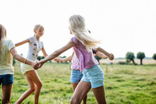 Happy Girls Dancing On A Field Together