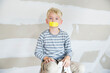 © Michelle Fraikin/Westend61 - Portrait of boy with taped mouth sitting on ladder in attic to be renovated