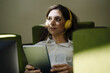 © Westend61 - Woman with headphones looking away while using digital tablet in office