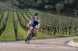 © Stefan Schurr/Westend61 - Germany, Baden-Wuerttemberg, Fellbach, man on racing cycle on country road through vineyards