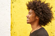 © victor espadas/Westend61 - Profile of happy young man with afro against yellow wall
