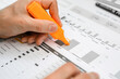 © Giorgio Magini/Westend61 - Close-up of businessman using highlighter on a report at desk in office