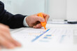 © Giorgio Magini/Westend61 - Close-up of businessman using highlighter on a report at desk in office